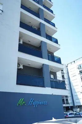 a tall apartment building with blue balconies at Apartman KoprenaZ in Banja Luka