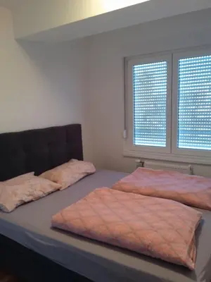 two beds in a bedroom with two windows at Apartman KoprenaZ in Banja Luka