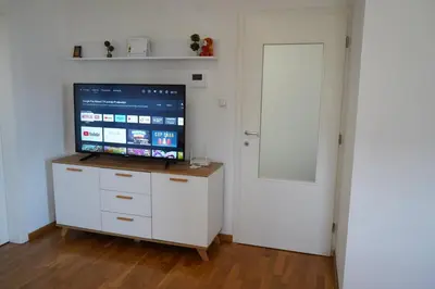 a room with a television on a dresser with a door at Apartman KoprenaZ in Banja Luka