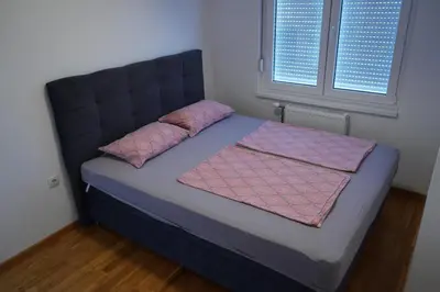 a bed in a room with two pillows on it at Apartman KoprenaZ in Banja Luka