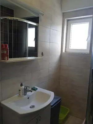 a bathroom with a sink and a mirror and a window at Apartman KoprenaZ in Banja Luka