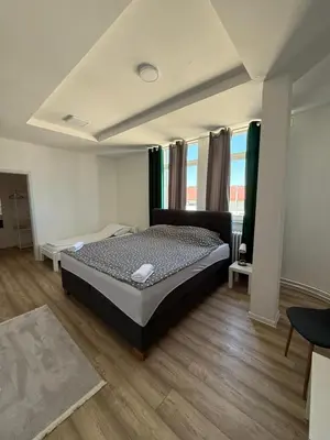 a bedroom with a bed in a room with wooden floors at Rooms ALEA in Sanski most