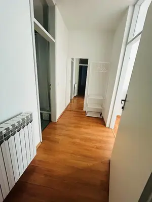a hallway of an apartment with white walls and wooden floors at Rooms ALEA in Sanski most