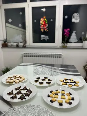 a table topped with plates of cookies andocolates at Rooms ALEA in Sanski most