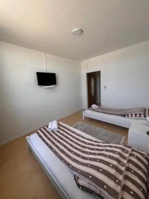 a room with two beds and a flat screen tv at Rooms ALEA in Sanski most