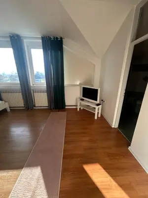 a living room with a television and a wooden floor at Rooms ALEA in Sanski most