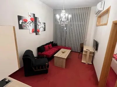 a living room with a red couch and a table at Apartmani Villa Grande in Bugojno