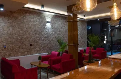 a waiting room with red chairs and a table at Apartmani Villa Grande in Bugojno