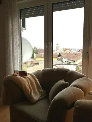 a couch in a living room with a large window at Stan na dan Kej Una in Bosanska Dubica