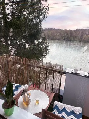 a patio with a table and a view of a lake at Stan na dan Kej Una in Bosanska Dubica