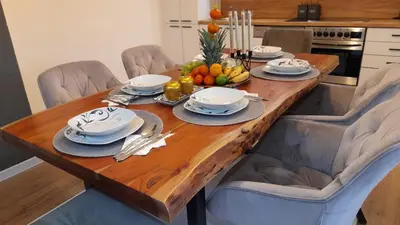 a wooden table with plates and bowls of fruit on it at Apartment City View in Bihać