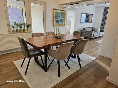 a dining room table and chairs in a living room at Apartment City View in Bihać