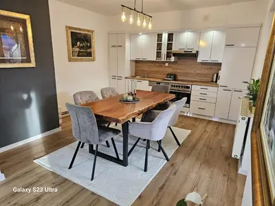 a kitchen with a wooden dining room table and chairs at Apartment City View in Bihać