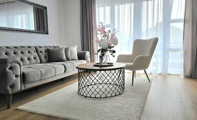 a living room with a couch and a table with flowers at Apartment City View in Bihać