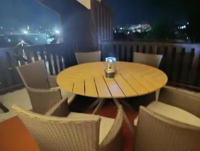 a wooden table and chairs on a balcony at Apartment City View in Bihać