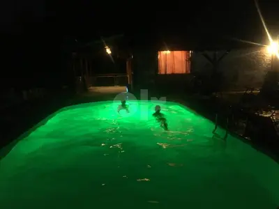 two children playing in a swimming pool at night at 