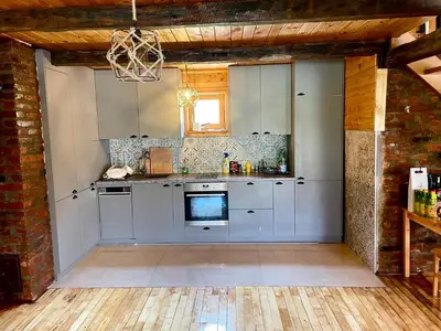 a kitchen with white cabinets and a brick wall at 