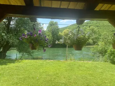 two potted plants hanging from a porch overlooking a river at 