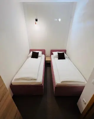 two beds sitting in a small room with at Stan na dan / rent-a-flat per day in Bugojno