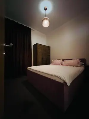 a bedroom with a bed with pink pillows on it at Stan na dan / rent-a-flat per day in Bugojno