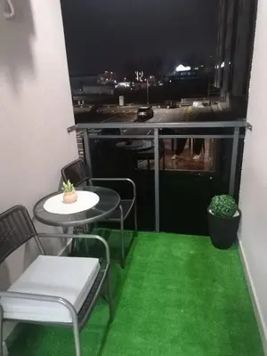 a balcony with green flooring and a table and chairs at Stan 23 in Banja Luka