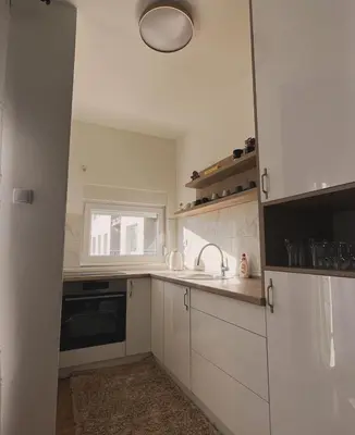 a kitchen with white cabinets and a sink and a window at Stan 23 in Banja Luka