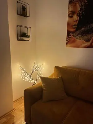 a living room with a couch and a picture of a woman at Stan 23 in Banja Luka