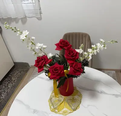 a red vase filled with red roses on a table at Luxapartman in Banja Luka