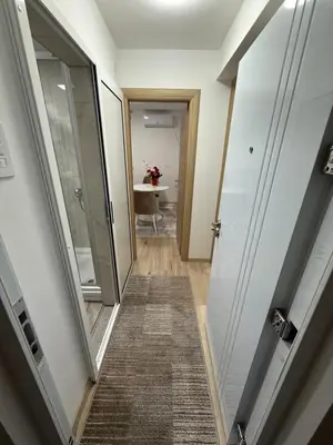 a hallway leading to a bathroom with a mirror at Luxapartman in Banja Luka