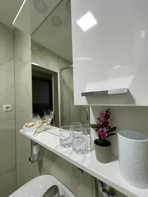 a bathroom with a sink and a counter with glasses on it at Luxapartman in Banja Luka