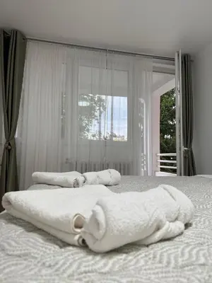 a bedroom with two towels on a bed with a window at Luxapartman in Banja Luka