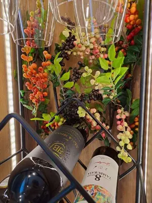 a bunch of grapes and wine bottles in a basket at Stojanović Diwine in Banja Luka