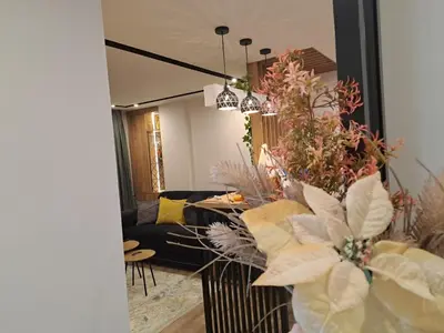a living room with a black couch and flowers at Stojanović Diwine in Banja Luka