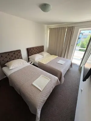 a hotel room with two beds and a window at Hotel Avanti in Zenica