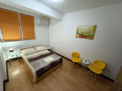 a small bedroom with a bed and two chairs at Hotel Avanti in Zenica