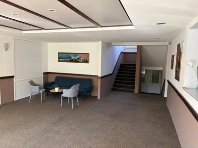 an office lobby with a blue couch and a table and chairs at Hotel Avanti in Zenica