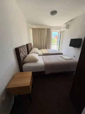 a hotel room with two beds and a window at Hotel Avanti in Zenica