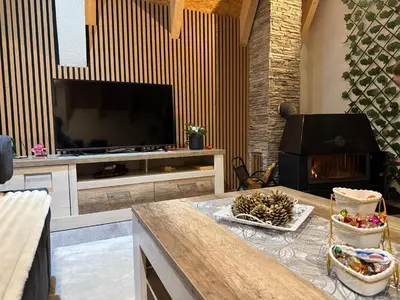 a living room with a flat screen tv and a fireplace at Kuća za odmor Villa Kovačević in Bihać