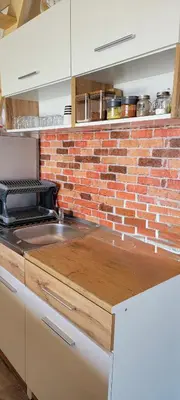 a kitchen with a brick wall and a counter top at Kuća za odmor Villa Kovačević in Bihać