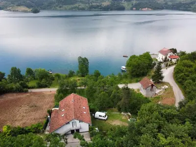 an aerial view of a house next to a lake at Apartman Manov - Ramsko jezero in Prozor