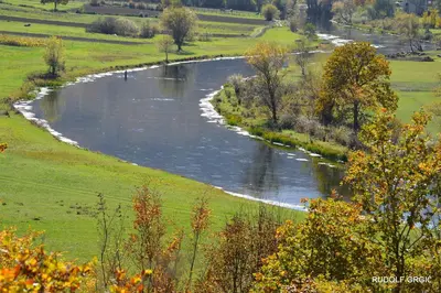 a river in the middle of a green field at Guest House Šobić in Šipovo