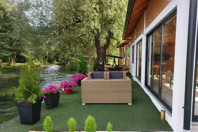 a porch with a couch and flowers on it at Guest House Šobić in Šipovo