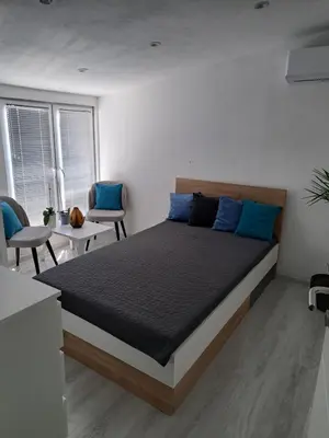 a bedroom with a large bed with blue pillows at Happy Vecation in Tuzla