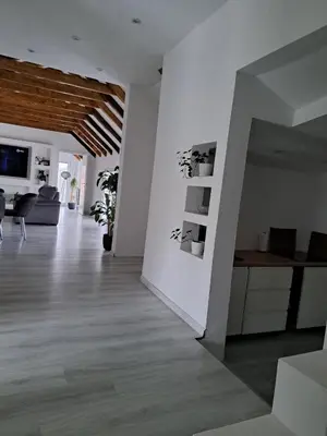 a living room with white walls and wooden floors at Happy Vecation in Tuzla