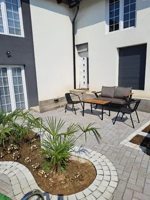 a patio with a table and chairs in front of a building at Happy Vecation in Tuzla