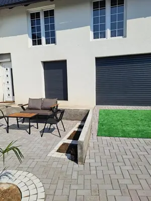 a patio with a couch and a table in front of a house at Happy Vecation in Tuzla