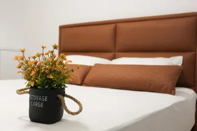 a flower pot sitting on a table next to a bed at West Wing - Apartmani Živinice in Živinice