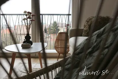 a living room with a vase on a table and a window at West Wing - Apartmani Živinice in Živinice