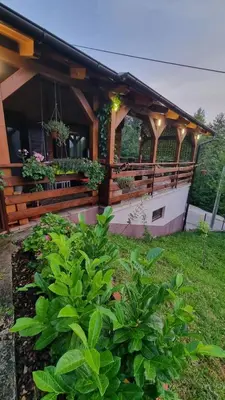 a wooden building with potted plants on it at Kuća za Odmor Naša Priča in Šipovo