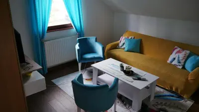 a living room with a couch and two blue chairs at Kuća za Odmor Naša Priča in Šipovo